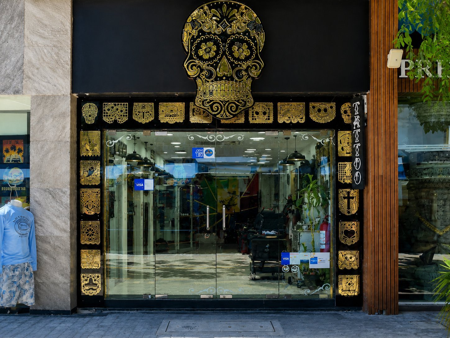 Store entrance with ornate gold skull and decorative frame above glass doors and windows